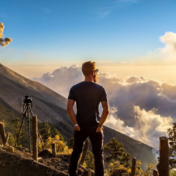 Levon Rivers with camera and tripod on a mountain